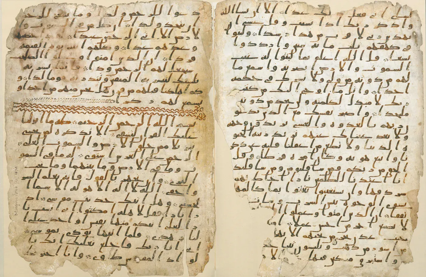 Två pergamentblad med tät arabisk skrift i brunt bläck; på det vänstra skiljer en vågig bård två suror åt. Kanterna är nötta och fläckiga.